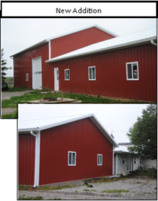 A large red building, with a tall area with garage door and a shorter area.